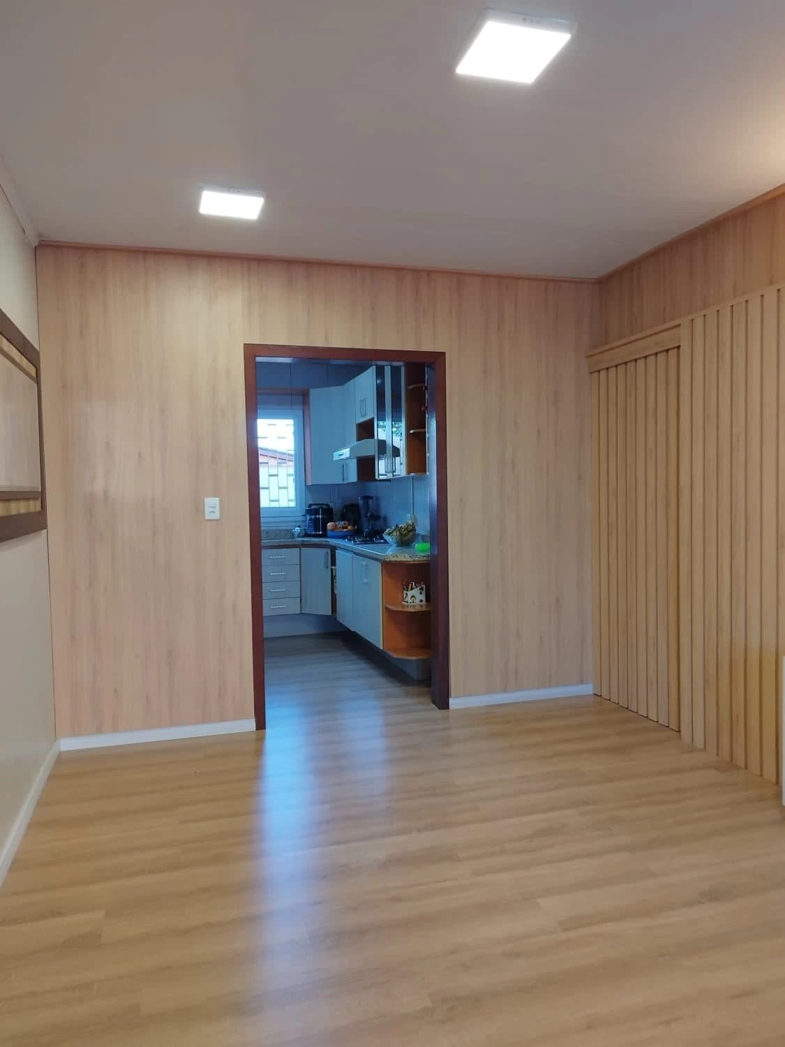 Home com painel amadeirado do piso ao teto — projeto executado pela Akai Móveis em Sapucaia do Sul