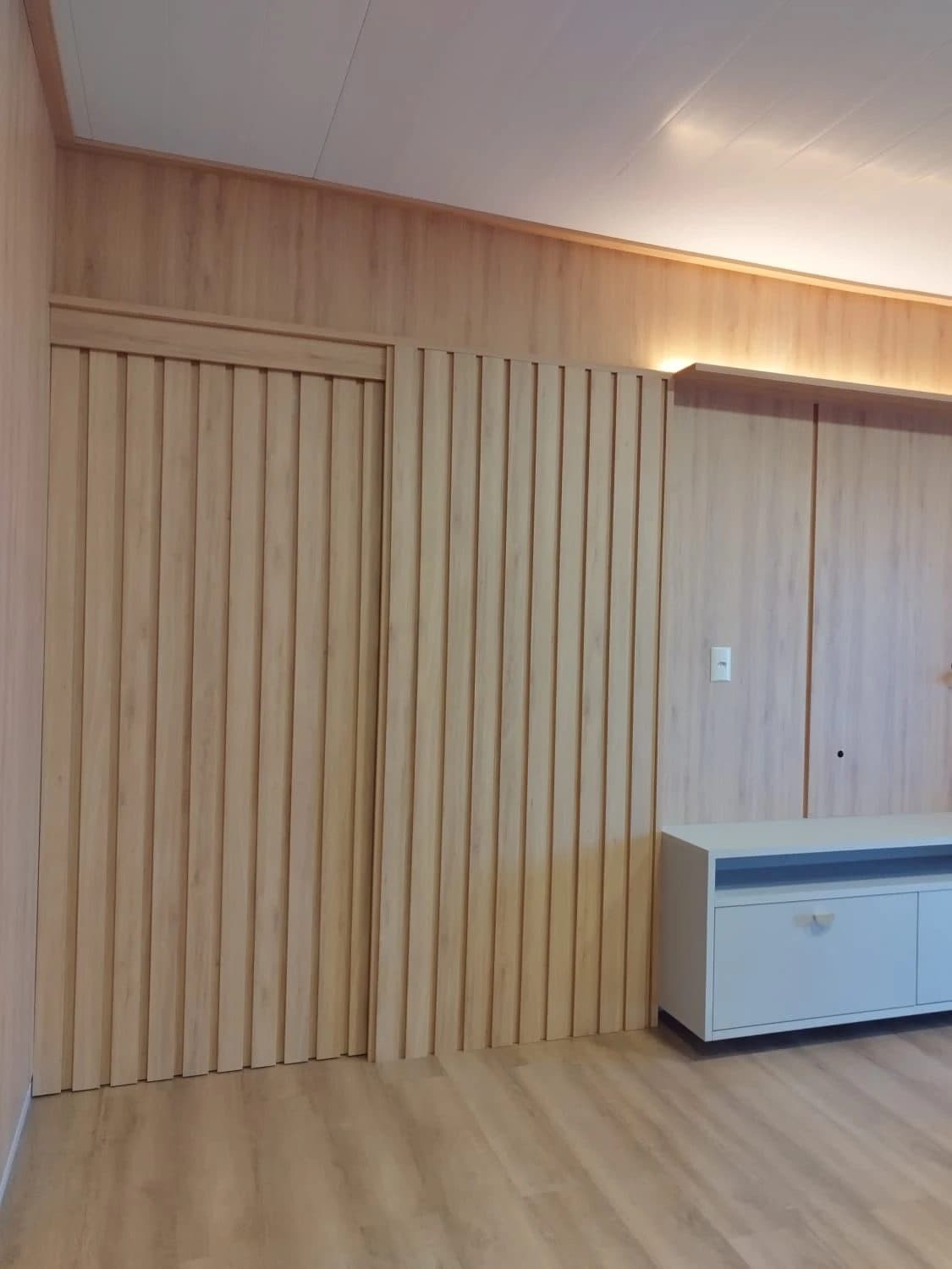 Home com painel amadeirado do piso ao teto — projeto executado pela Akai Móveis em Sapucaia do Sul