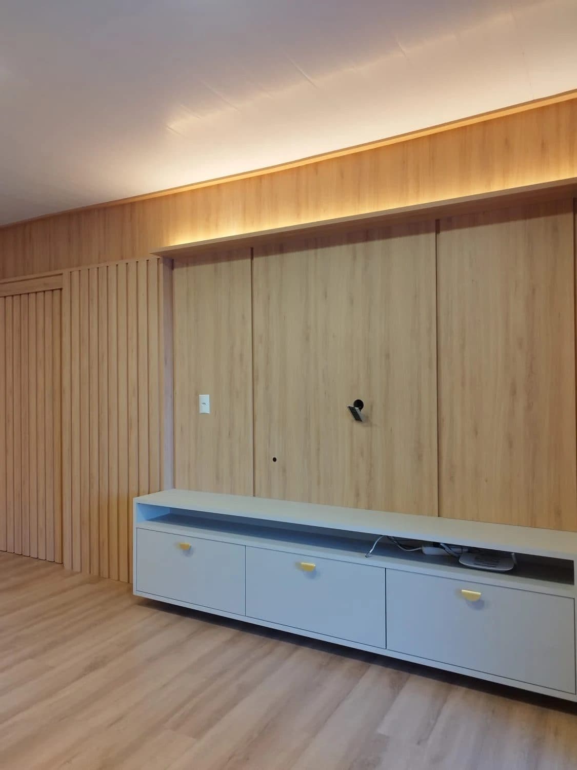 Home com painel amadeirado do piso ao teto — projeto executado pela Akai Móveis em Sapucaia do Sul