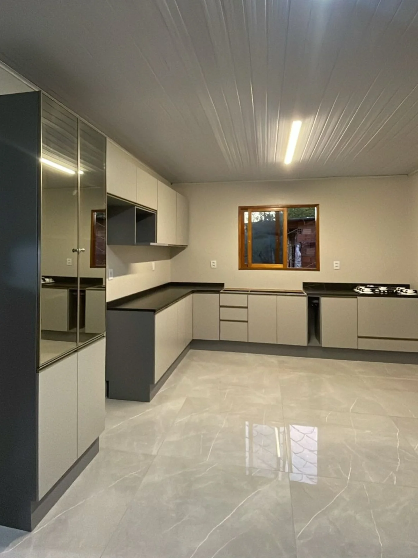 Cozinha modulada com torre e portas espelhadas — projeto executado pela Akai Móveis