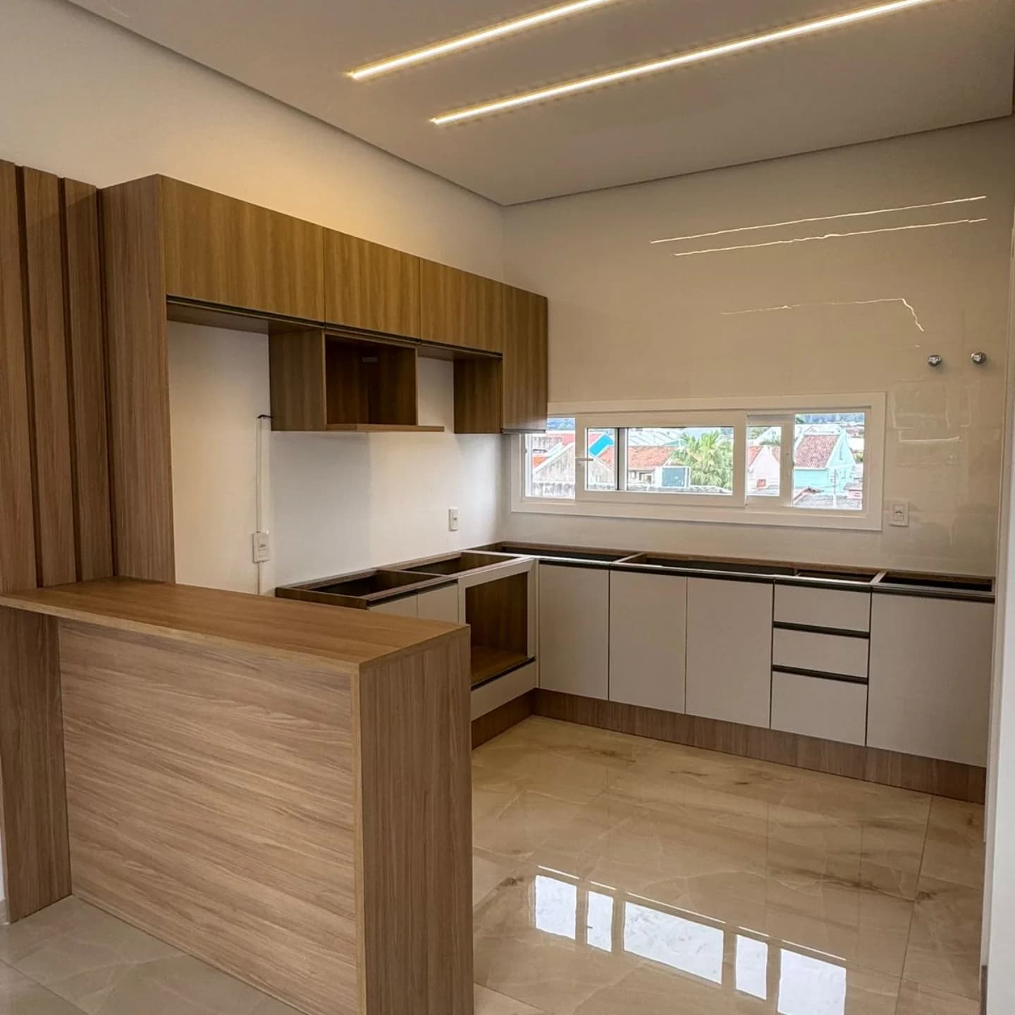 Cozinha modulada em U com balcão amadeirado — projeto executado pela Akai Móveis